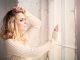 Close up of woman looking lout of a window whilst feeling sad