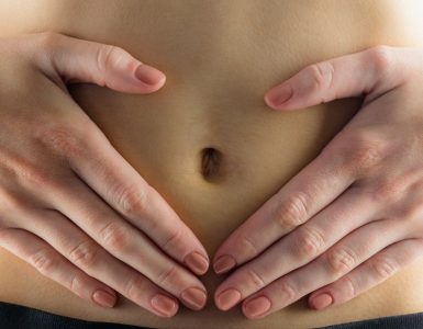 CLose up of hands on tummy to represent indigestion