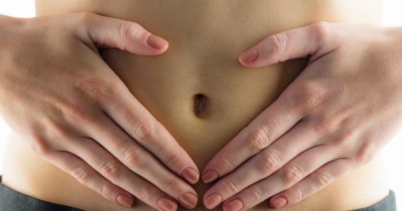 CLose up of hands on tummy to represent indigestion