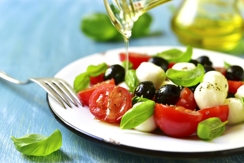 A salad of olives, tomatoes, cheese and basil representing the mediterranean diet