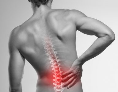 A black and white picture of a man's back with the spine and lower back highlighted red to represent back pain