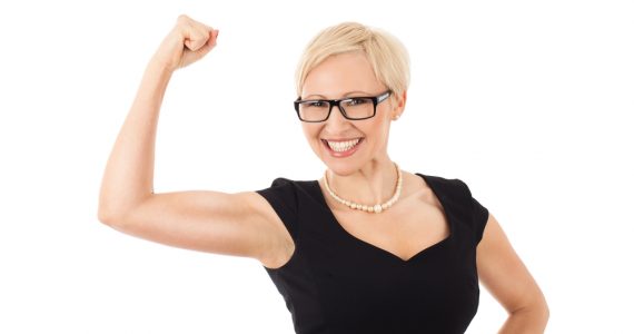 Woman wearing black dress with arm raised in triumph at her weight loss