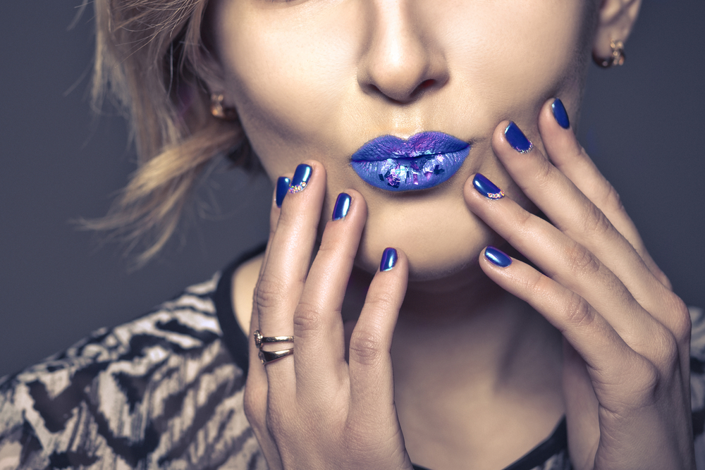 Close up of woman with blue lipstick and blue nails