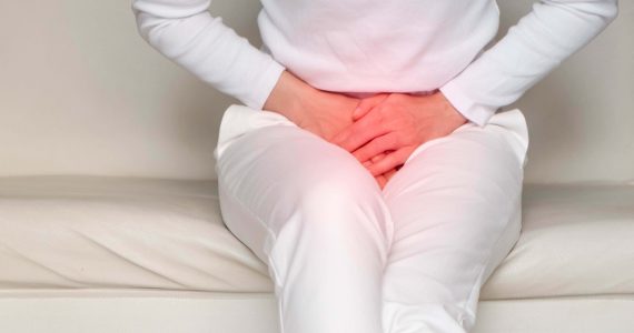 Woman resting hands over groin area depicting bladder incontinence