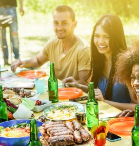 A group of people have fun at a bbq eating outdoors
