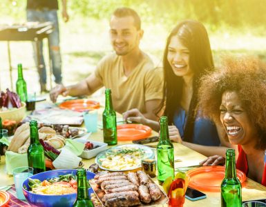 A group of people have fun at a bbq eating outdoors