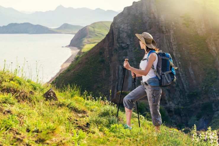 A woman hiking outdoors overlooking a sea cliff