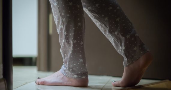 Close up of woman in pyjamas visiting the bathroom at night