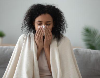 Woman with a cold sitting with a blanket on