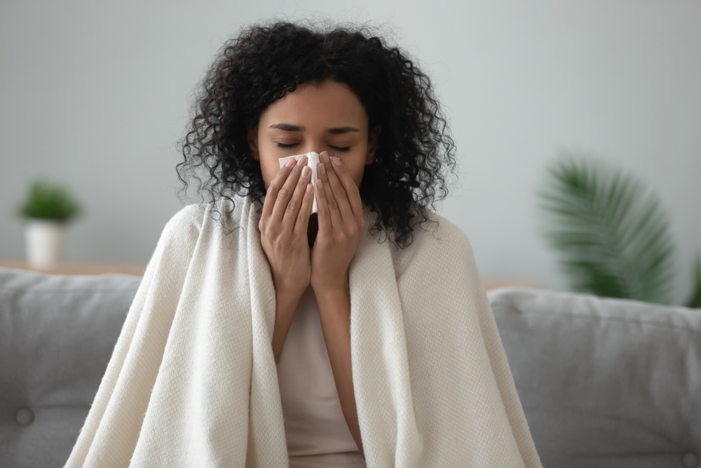 Woman with a cold sitting with a blanket on