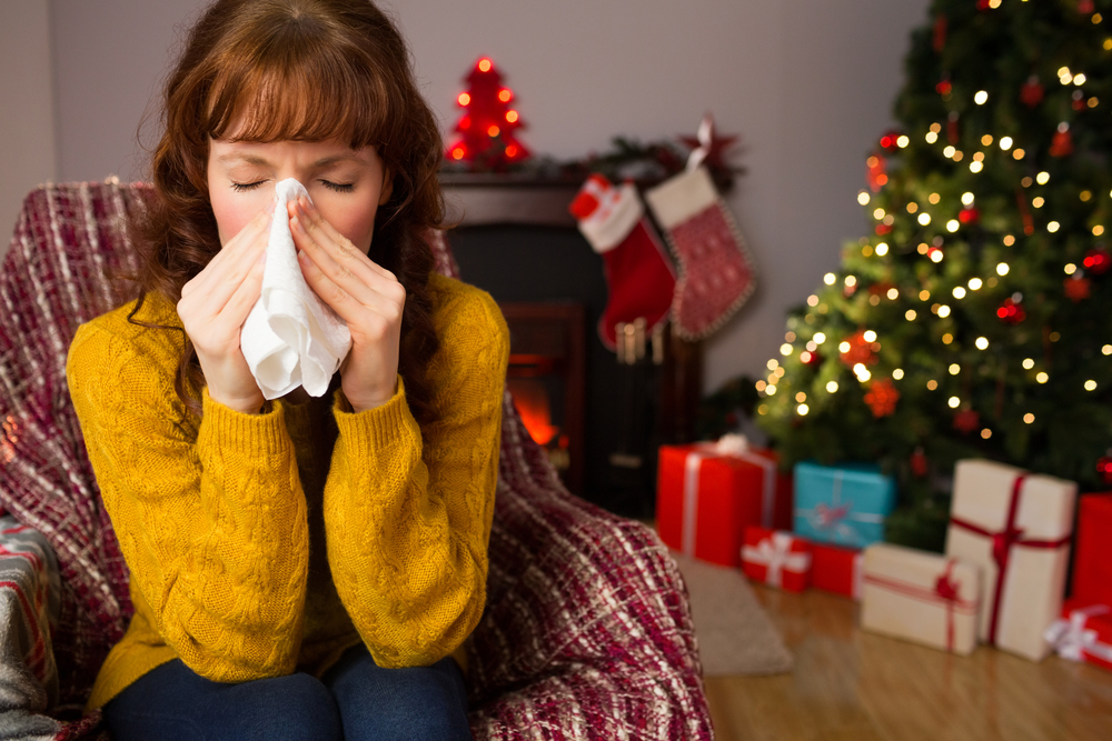 Woman blowing her nose with a cold at Christmas