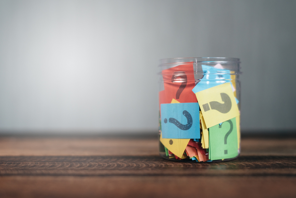 A jar filled with postits with question marks on to represent asking questions