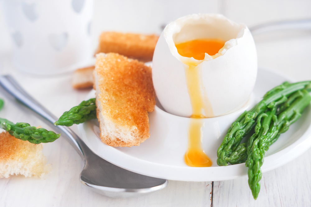 Boiled egg with soldiers and asparagus