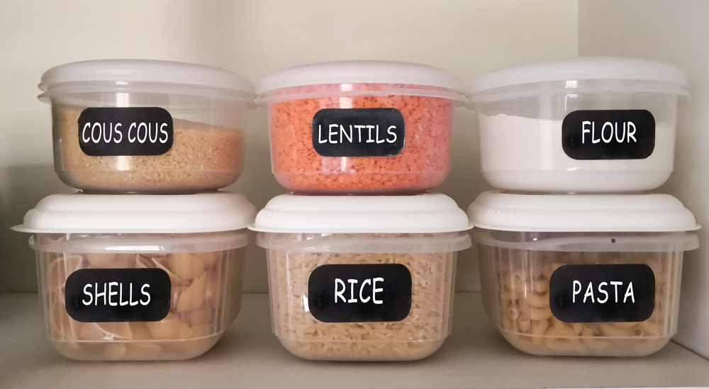 Dry foods stored in tupperware in a cupboard