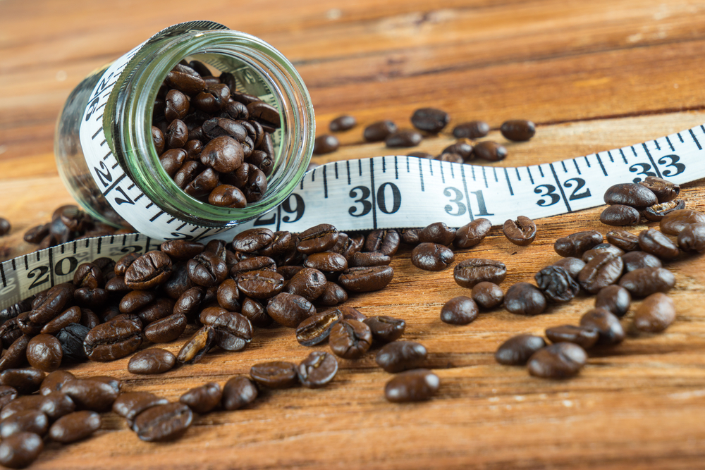 Coffee beans and a measuring tape to show how coffee can support weight loss