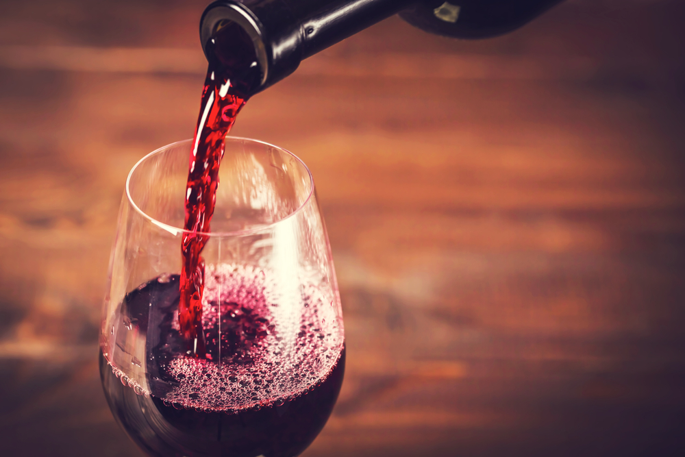 Close up of someone pouring a glass of red wine