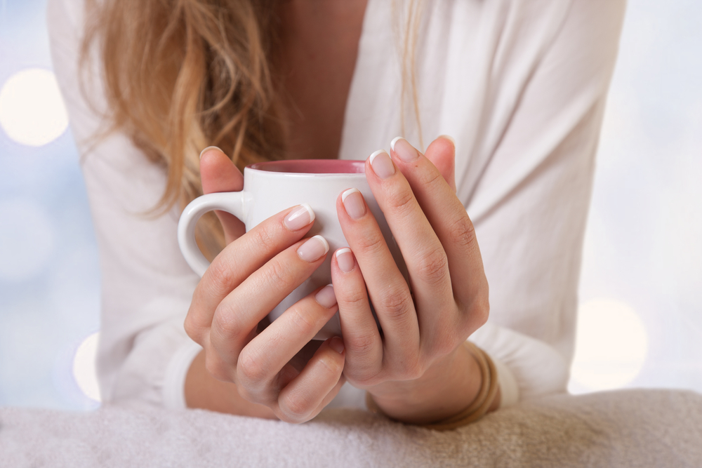 Close up of a woman holding a mug of warm milk