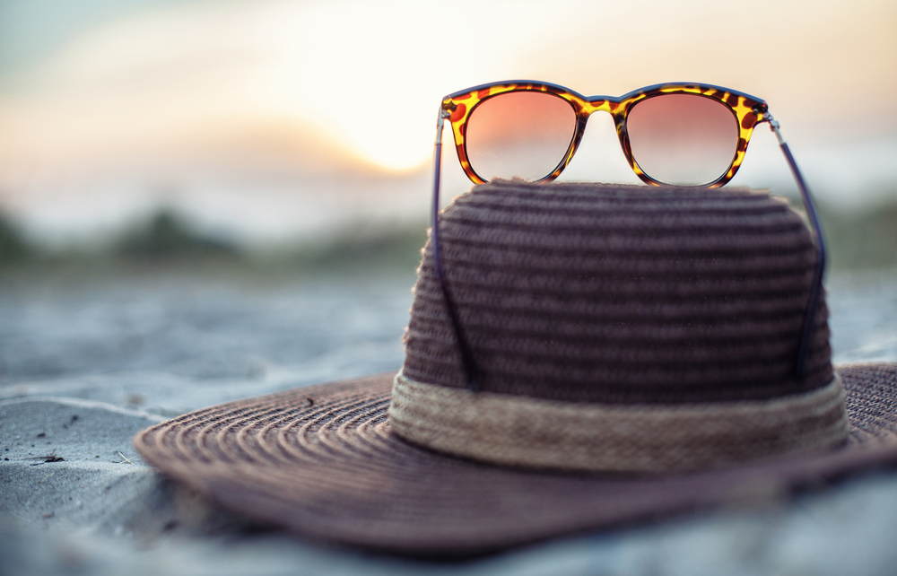 Sun hat and sun glasses on a beach