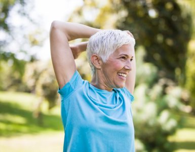 Older woman stretching and exercising outdoors