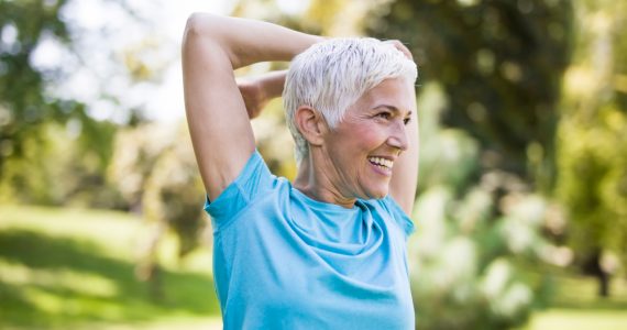 Older woman stretching and exercising outdoors