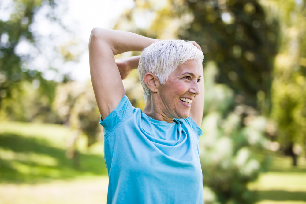 Older woman stretching and exercising outdoors