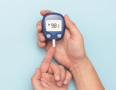 Close up of someone wiht diabetes using a blood sugar testing machine