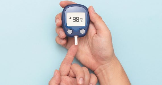 Close up of someone wiht diabetes using a blood sugar testing machine