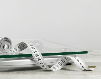 A measuring tape and scales to represent weight management