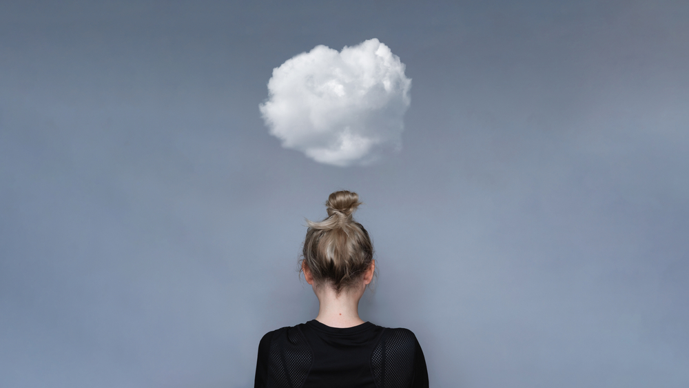 Woman with small cloud overhead to represent mental health worries