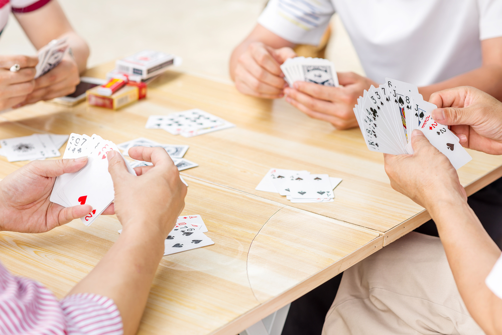 People playing a hand of cards