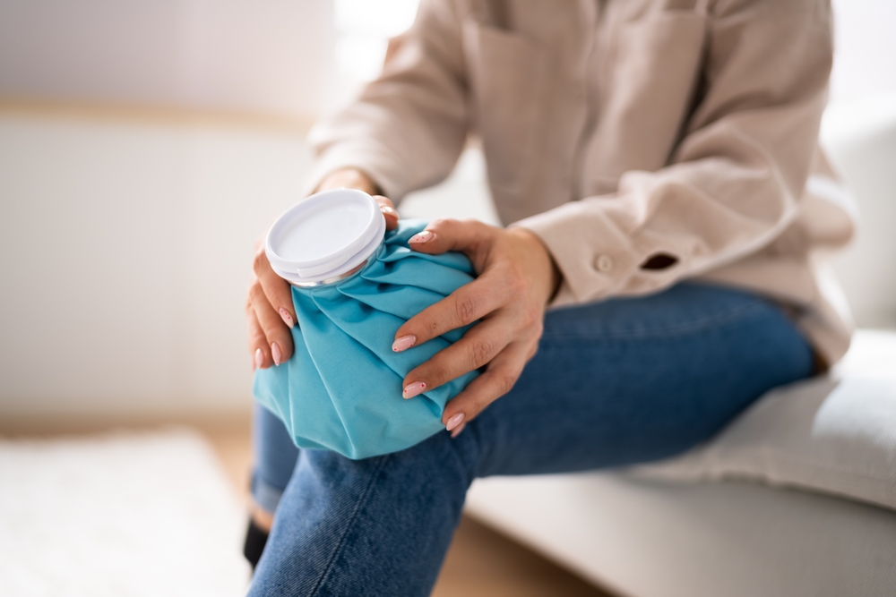 Woman applying cold compress to knee