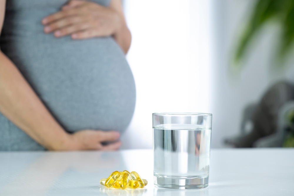 Close up of pregnant woman and Vitamin D3 supplements