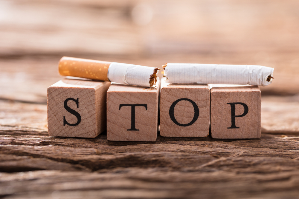 Broken cigarette on top of blocks spelling out 'stop' to represent stopping smoking