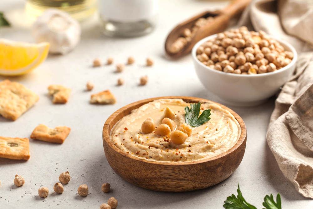 A bowl of hummus surrounded by chick peas